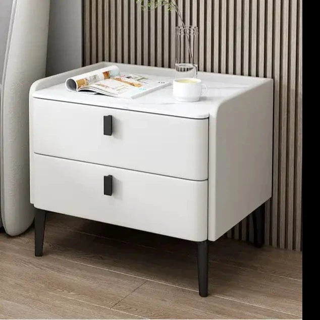 a white nightstand with a magazine on top of it
